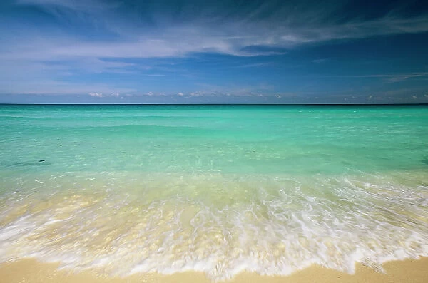 Clear blue water and wispy clouds along the beach at Cancun