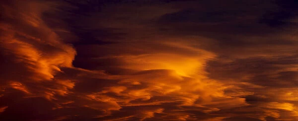 Dramatic colourful warm glowing clouds at sunset
