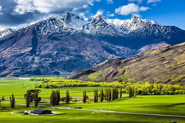 Farmland and mountain range near the Treble Cone ski area at Glendhu Bay in the Otago Region of New Zealand