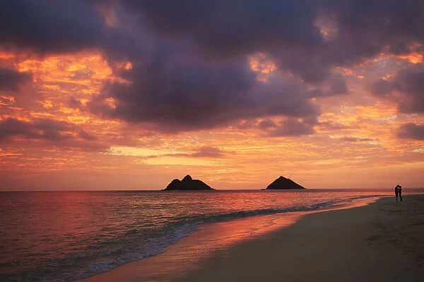 Hawaii, Oahu, Kailua, Lanikai, Vibrant sunset with a couple embracing on beach