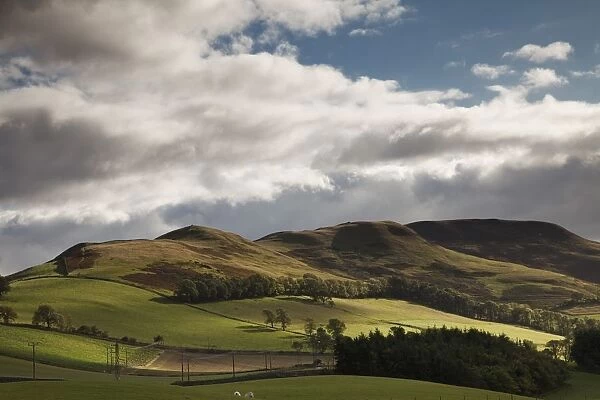 A Landscape With Rolling Hills And Powerlines And Clouds Overhead; Scottish Borders, Scotland
