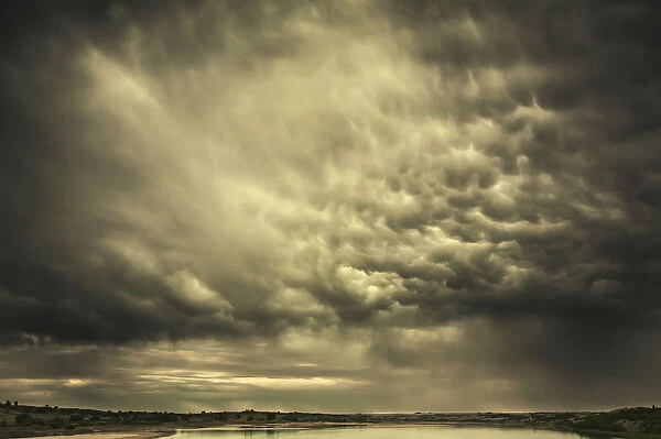 Mammatus storm clouds above a lake in the saskatchewan prairies; Saskatchewan, canada