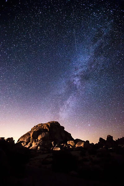 The Milky Way in starry night sky over a granite dome, Joshua Tree National Park, California, USA