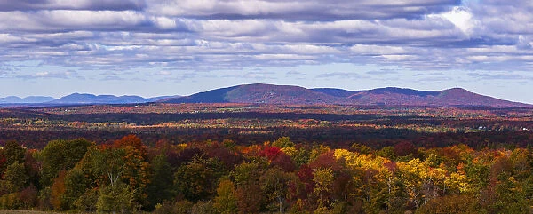 Mountain Range In Autumn Colours With Autumn Coloured Forest In The Foreground; West Bolton, Quebec, Canada