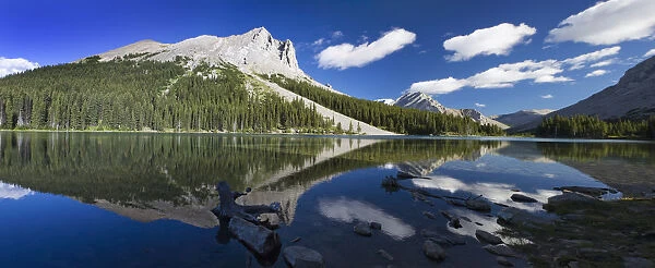 Panorama of a mountains reflecting on a mountain lake with blue sky and clouds in kananaskis provincial park; Alberta canada
