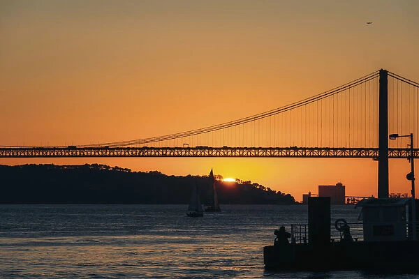 Silhouette of 25 de Abril Bridge crossing the Tagus River at sunset, Lisbon, Estremadura, Portugal