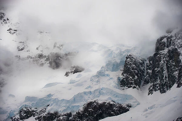 Storm clouds over rocky glacier at Lemaire Channel, Antarctic Peninsula, Antarctica