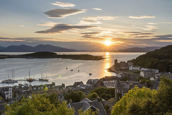 The sun sets over the harbour waters of Oban, Scotland