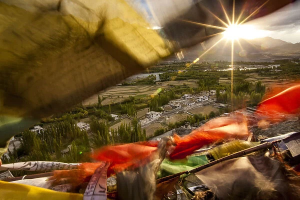 The Sun Sets Over A Ladakhi Village Outside Of Leh, Viewed Through The Flapping Prayer Flags; Ladakh, India