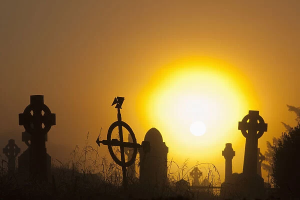 Sunrise at aghadoe heights graveyard with silhouetted tombstones; Killarney, county kerry, ireland