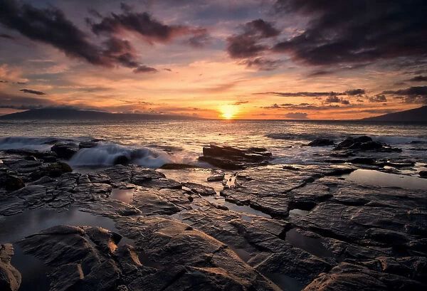 Sunset Over The Ocean With Wet Black Rock Along The Shore; Hawaii, United States Of America