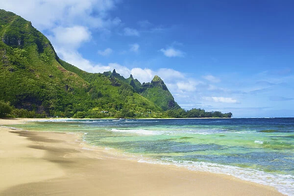 View Of The Coastline Of Kauai With Rugged, Green Mountains And A Sand Beach; Wailua, Kauai, Hawaii, United States Of America