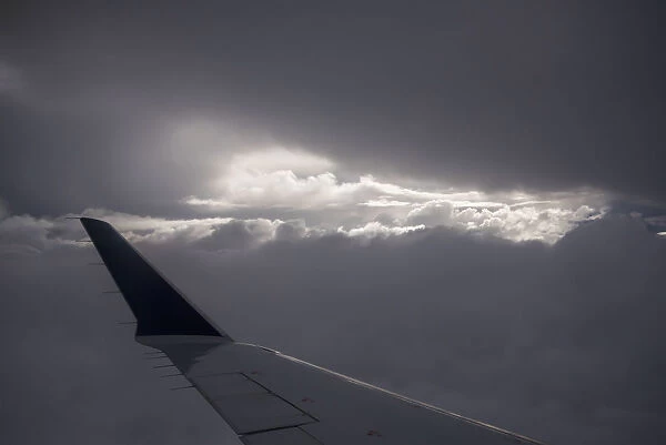 Wing Of An Airplane With Sunlight Shining Through Storm Clouds; Astoria, Oregon, United States Of America
