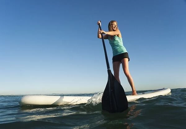 A Woman Paddling While Standing On A Surf Board Off Dos Mares Beach; Tarifa, Cadiz, Andalusia, Spain