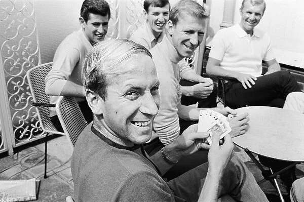 Bobby Charlton holds a full house in a game of cards with team mates, l-r Peter Bonetti