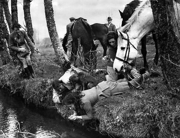 After the horses have drunk from the swift roadside stream the riders quench their thirst