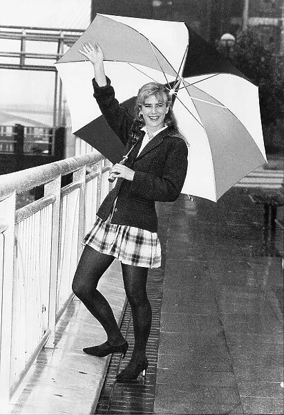 Imogen Stubbs Actress holding up Umbrella in rain and waving