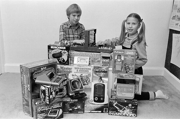 Two lucky children surrounded by a selection of electronic games available in the shops