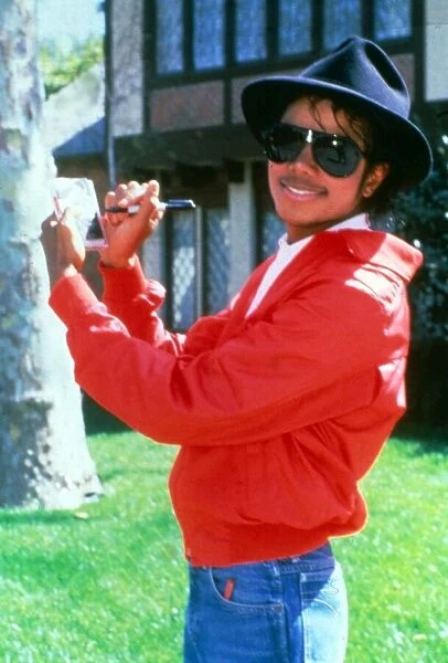 Michael Jackson signing his autograph at his home. April 1984