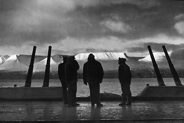 Pilots of the Royal Navy Fleet Air Arm watch the sun strike the snow covered mountains