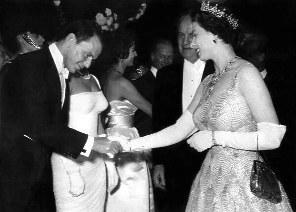 Queen Elizabeth II, Frank Sinatra bows as he meets the Queen at the premiere of the film
