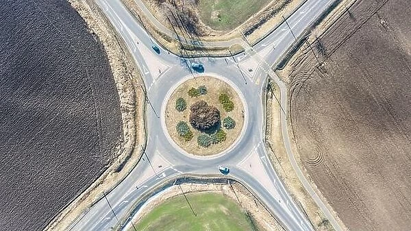 Aerial view of roundabout in countryside with rural, agriculture fields. Circle road: European roundabout around agriculture field with little traffic