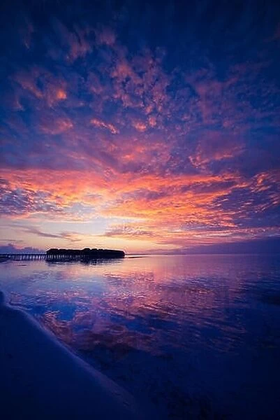 Amazing abstract background. Beautiful sunset colors in Maldives. Long jetty and luxury overwater villas