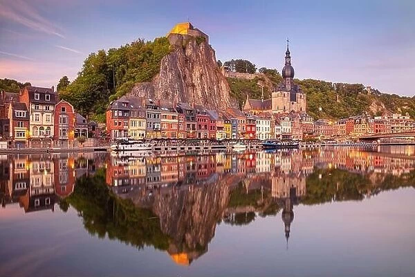 Dinant, Belgium. Cityscape image of beautiful historical city of Dinant with the reflection of the city in the Meuse River at summer sunset