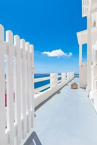 Open white door overlooking the sea and Caldera, famous door to Santorini, Greece. Luxury travel vertical banner, amazing sea view, blue sky landscape