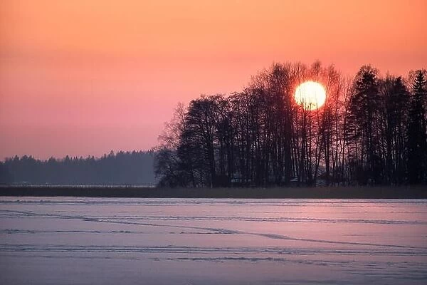 Scenic sunset with big sun at winter evening in Finland
