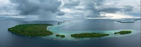 Storm clouds dump rain near a remote tropical island in the Solomon Islands. This beautiful country is home to spectacular marine biodiversity