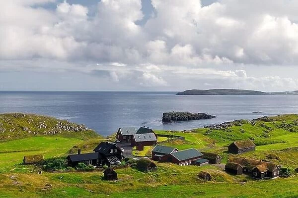 Summer view of small village with typical faroese turf-top houses on outskirts of Torshavn city, capital of Faroe Islands, Streymoy island, Denmark