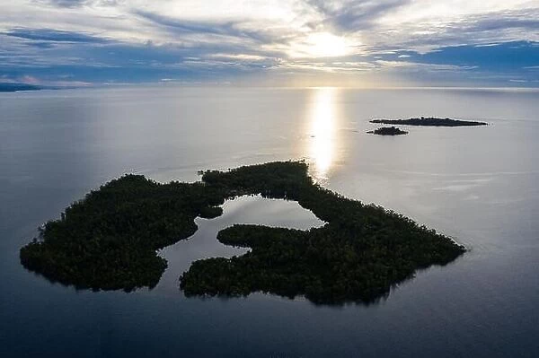 Sunrise illuminates a remote island and lagoon off the coast of New Britain, Papua New Guinea. This area is home to extraordinary marine biodiversity