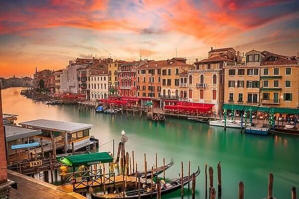 Venice, Italy overlooking boats and gondolas in the Grand Canal at dusk. (Sign reading in Italian 'No Mafia Venezia e Sacra' translates in English to