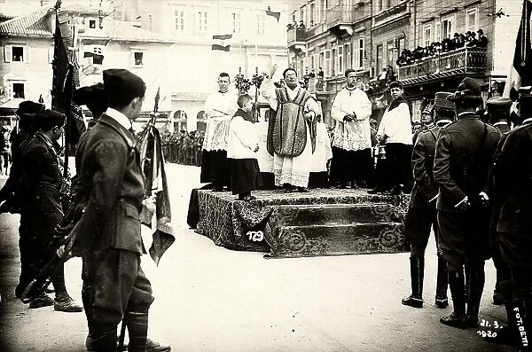 Celebration of a religiuos ceremony in a road of Fiume in presence of a group of officers and of Italian legionaries. The photograph was taken during the occupation of the city by part of the Italian legionary forces, which were headed by Gabriele D'Annunzio
