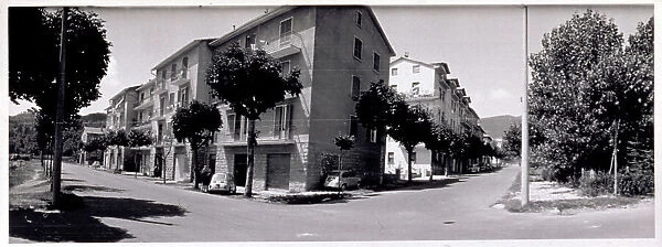 A crossing of tree-lined streets, with apartment houses, in Abbadia San Salvatore. To be noted a Fiat 600 and a Fiat 500 parked