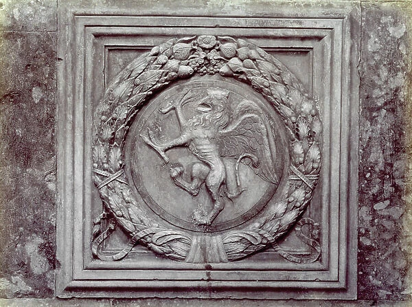 Delicate bas-relief by Agostino di Duccio of the mythological griffin set in a plant wreath. The low relief is part of the sculptural decoration of the Oratory of San Bernardino in Perugia