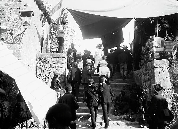 Group climbing a staircase in a village, Castrogiovanni (today Enna)