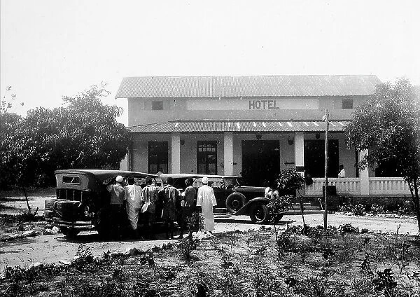 A group of people with cars, in front of a hotel in Dodoma