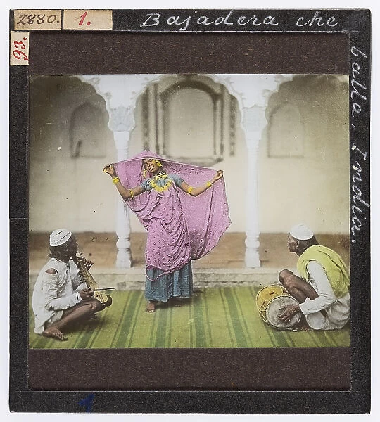 Indian dancer in traditional clothes accompanied by two musicians