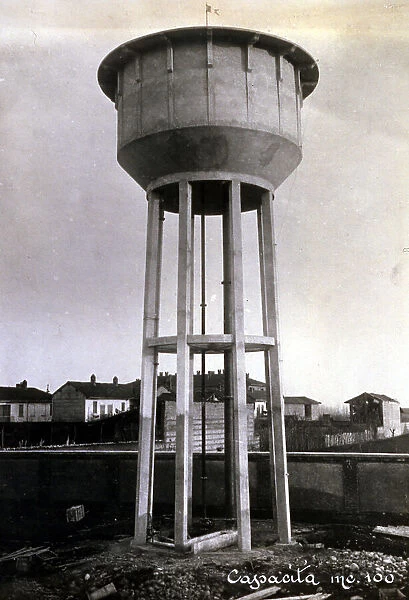 Large reinforced concrete cistern of the electrochemical plant Rossi of Legnano (Milan). In the background a few houses