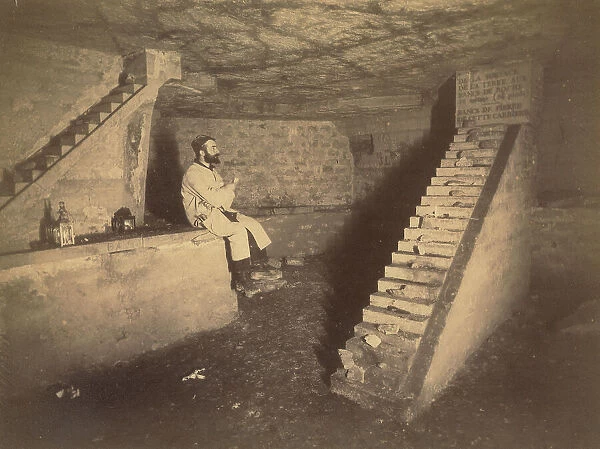 A man in the catacombs of Paris (ossuaire municipal): underground ossuary of the town of Paris in the galleries of an old quarry