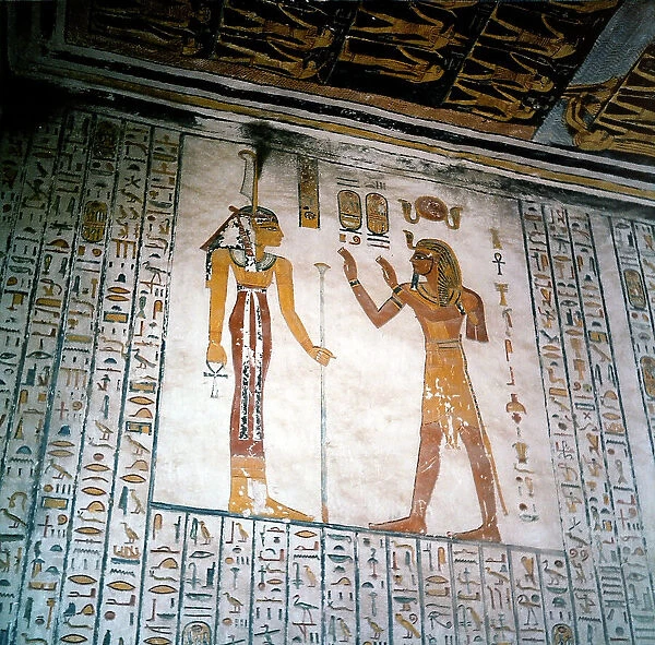 A mural painting in a New Kingdom tomb in Thebes. The deceased pharaoh is seen facing the goddess Isis, the scene is framed by hieroglyphic inscriptions