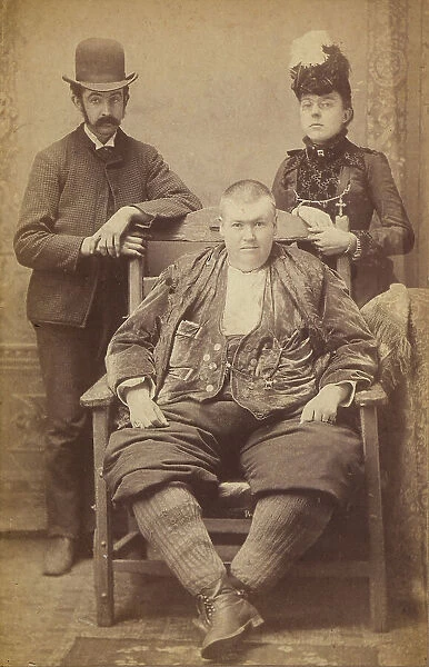 Portrait of an obese youth flanked by a man and a woman