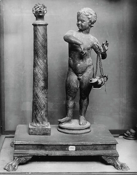 Putto holding an oil lamp and a small column topped by a head, from Pompeii, now in the National Archaeological Museum in Naples