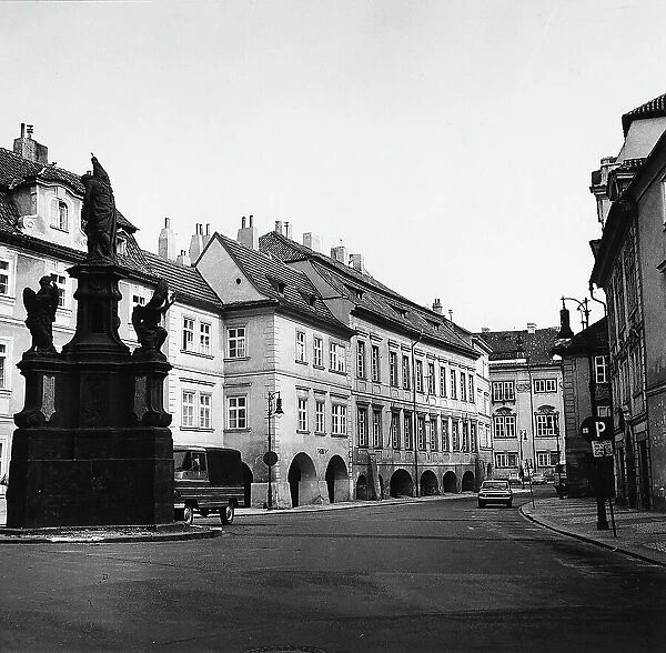 A street in the Mal Strana quarter in Prague. A commemorative monument is in the left foreground