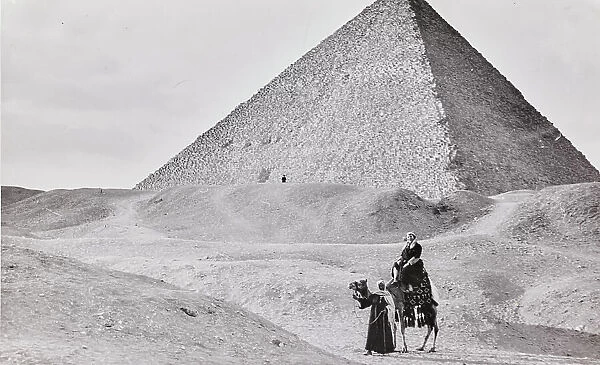 Tourist on a camel and, in the background, the Great Pyramid of Giza