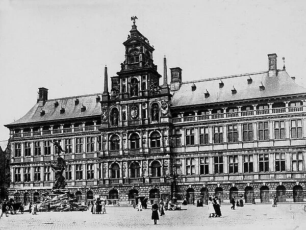 View of the palace of Stadhuis, which at the time of the photograph was the Hotel de Ville, in Antwerp, in Belgium. On the left, the fountain with the statue of Silvius Brabo, Roman mythical legionary, nineteenth-century work, can be seen