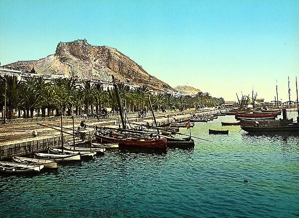 View of the sea promenade of Alicante, Spain. In the background, the hill where the Castle of Saint Barbara stands on
