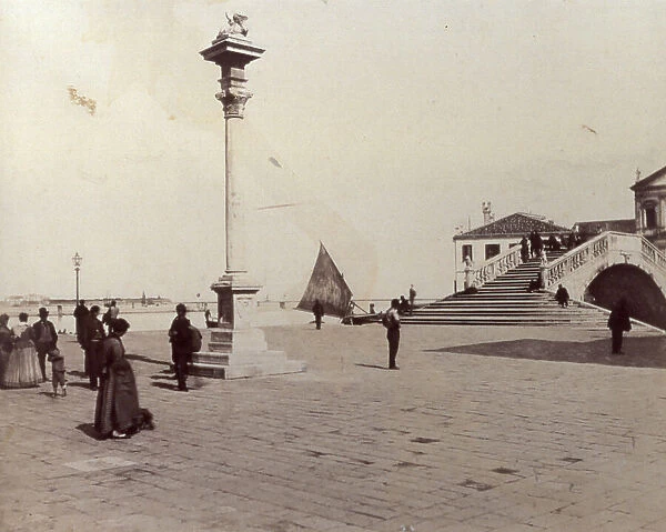 The wharf at Chioggia with the column and statue of the Lion of St. Mark on top; on the right, Ponte Vigo